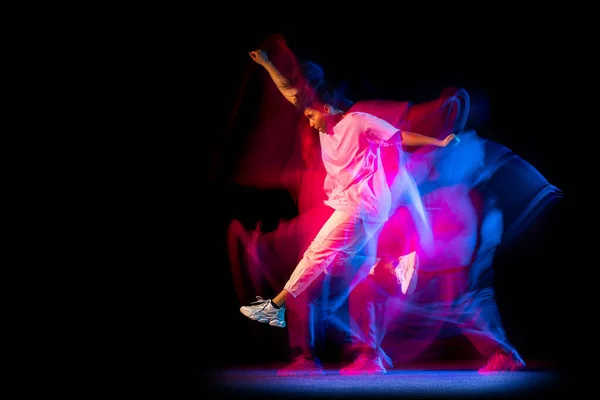 Heyecanlı genç kız beyaz kostümlü hip-hop dansı yapıyor karanlık arka planda neon ışıklı dans salonunda izole edilmiş.. — Stok fotoğraf