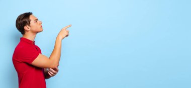 Profil görüntüsü, genç yakışıklı bir adam, öğrenci mavi stüdyo arka planında izole görünüyor.