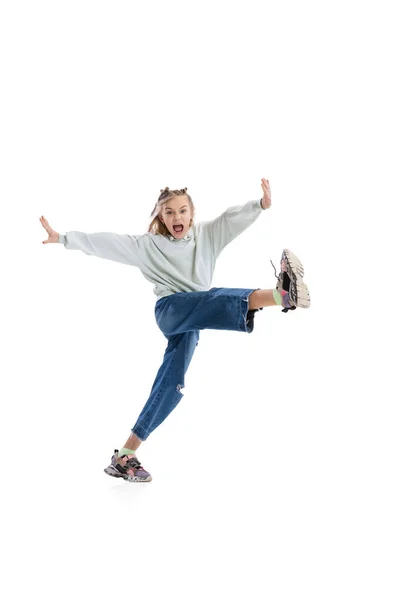 Dynamisch portret van klein meisje, kind in casual kleding springen, plezier geïsoleerd op grijze studio achtergrond. — Stockfoto