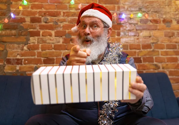 Heureux vieil homme barbu assis à la maison et célèbre le Nouvel An avec des amis et de la famille par appel vidéo. — Photo