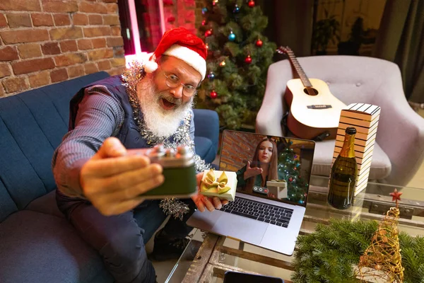 Hombre barbudo viejo emocional sentado en casa y celebra el Año Nuevo con amigos y familiares por medio de videollamada. — Foto de Stock