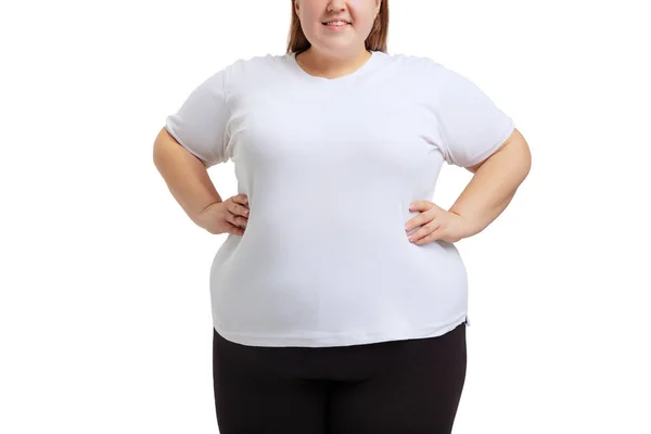 Imagem recortada de mulher plus-size vestindo camiseta branca e jeans posando isolada no fundo do estúdio branco. — Fotografia de Stock