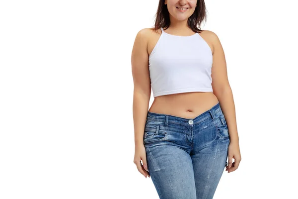 Imagem recortada de mulher plus-size vestindo camiseta branca e jeans posando isolada no fundo do estúdio branco. — Fotografia de Stock