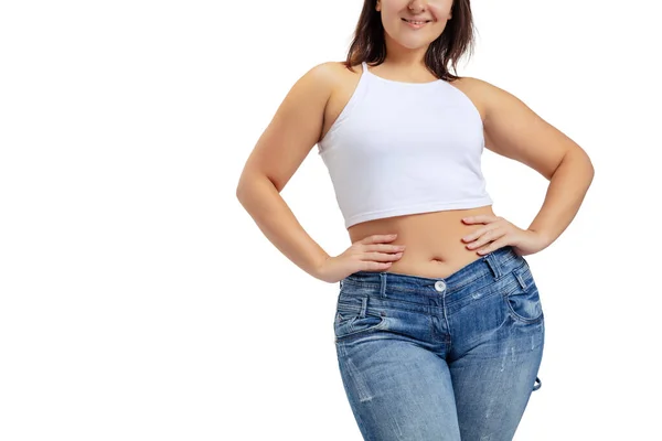 Ausgeschnittenes Bild einer Plus-Size-Frau mit weißem T-Shirt und Jeans, die isoliert auf weißem Studiohintergrund posiert. — Stockfoto