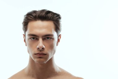 Beyaz stüdyo arka planında izole edilmiş yakışıklı bir adamın yakın plan portresi. Erkeklerin sağlık ve güzellik anlayışı