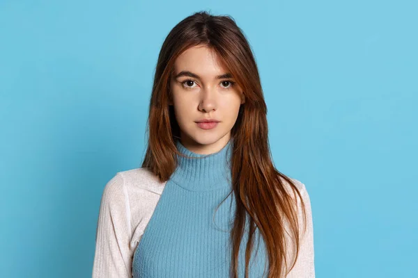 Hermoso retrato femenino de media longitud aislado en el fondo del estudio azul. Emociones humanas, concepto de expresión facial — Foto de Stock