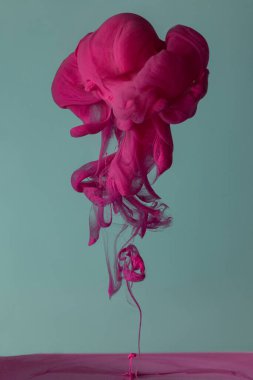 Renkli sıvı, mürekkep, boya ve mavi-gri stüdyo arka planında fotokopi uzayıyla yakılmış sıvı.