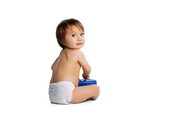 Portrait of little boy, baby, child in diaper playing with toy safe box isolated over white studio background. Childhood concept — Fotografia de Stock