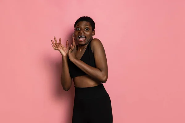 Studioaufnahme einer jungen verängstigten afrikanischen Frau, die isoliert auf rosa Studiohintergrund mit Kopierplatz für Werbung steht. — Stockfoto