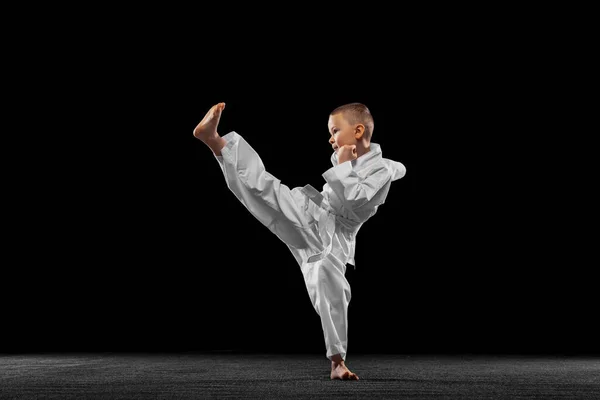 Dinamikus portré kisfiúról, fiatal karate edzés egyedül elszigetelt fehér háttérrel. A sport, az oktatás és a készségek fogalma — Stock Fotó