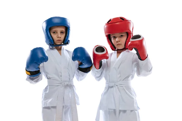 Närbild två små barn, pojkar, taekwondo idrottare bär doboks och sport uniformer isolerad på vit bakgrund. — Stockfoto