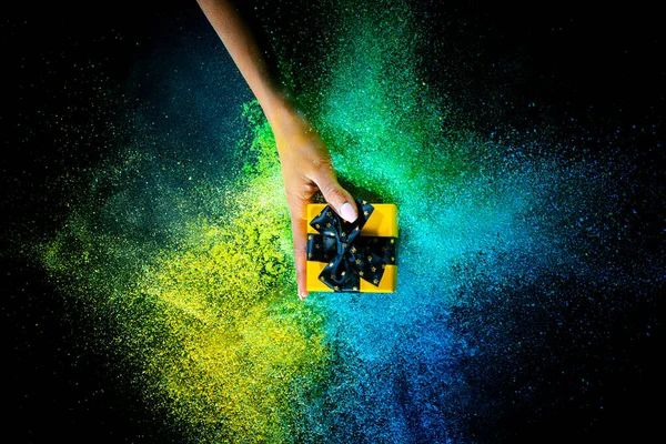 Female hand and explosion of colored, neoned powder on black studio background with copy space. Magazine cover, wallpaper design — 图库照片