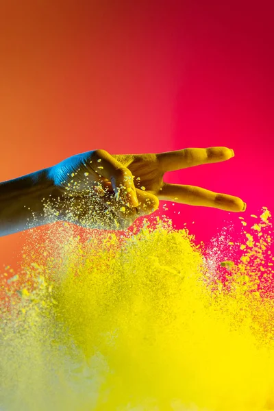 Kobieca ręka i eksplozja kolorowego, neoned proszku na różowym tle studio z miejsca do kopiowania. Okładka magazynu, projekt tapety — Zdjęcie stockowe
