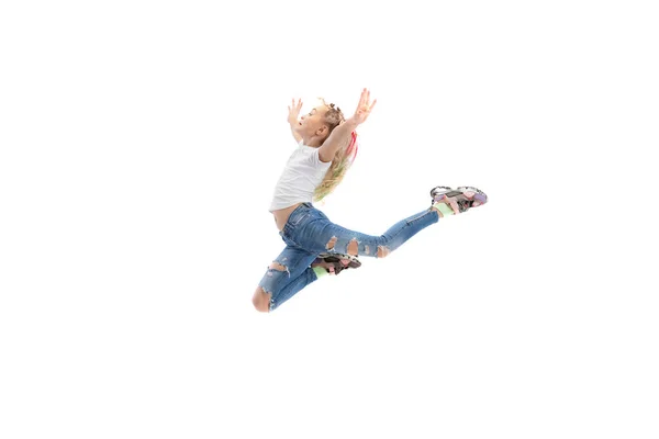 Dynamic portrait of little girl, kid in casual clothes jumping isolated on white studio background. — Fotografia de Stock
