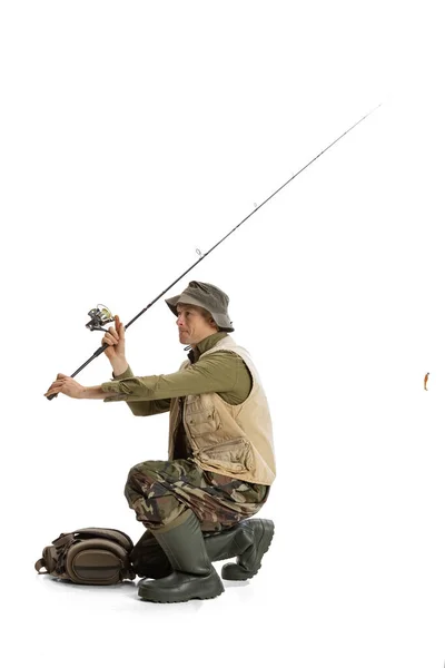 Retrato de joven, pescador profesional con caña de pescar, spinning y equipo que va al río aislado sobre fondo blanco del estudio —  Fotos de Stock