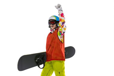 Parlak spor giyimli, gözlüklü ve kasklı mutlu genç kız beyaz stüdyo arka planında tek başına snowboard yapıyor. Kış sporları kavramı