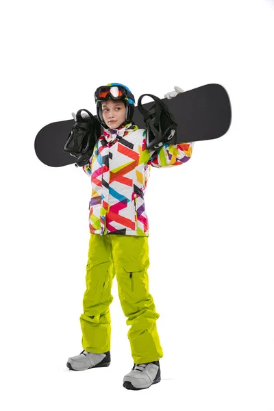 Happy young girl in bright sportswear, goggles and helmet standing with snowboard isolated on white studio background. Concept of winter sports — Fotografia de Stock