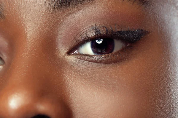 Close-up face of young african woman with well-kept skin isolated on dark studio background. Details. — Zdjęcie stockowe