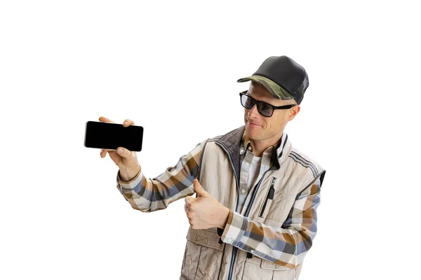 Retrato de jovem vestindo roupas estilo esporte usando telefone isolado sobre fundo estúdio branco — Fotografia de Stock