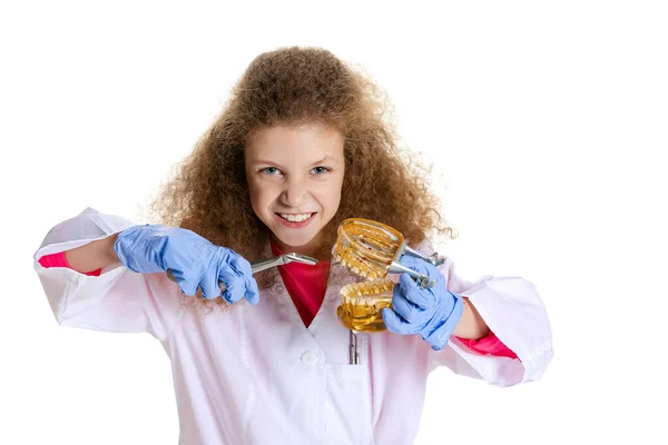 Halvlångt porträtt av söt vacker liten flicka, barn i bild av tandläkare bär vit labbrock och handskar isolerade på vit studio bakgrund — Stockfoto