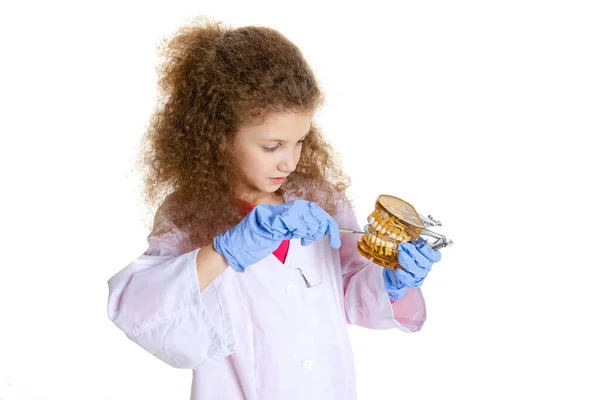 Μισού μήκους πορτρέτο του χαριτωμένο όμορφο κοριτσάκι, παιδί κατ 'εικόνα του οδοντίατρου φορώντας λευκό εργαστηριακό παλτό και γάντια απομονώνονται σε λευκό φόντο στούντιο — Φωτογραφία Αρχείου