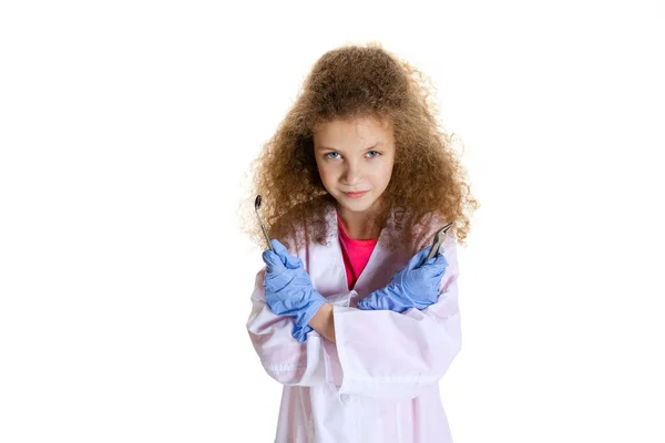 Serieus klein meisje, kind in beeld van tandarts het dragen van witte labjas en handschoenen geïsoleerd op witte studio achtergrond — Stockfoto