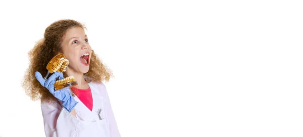 Flyer with excited little girl, child in image of dentist doctor wearing white lab coat and gloves isolated on white studio background — Fotografia de Stock