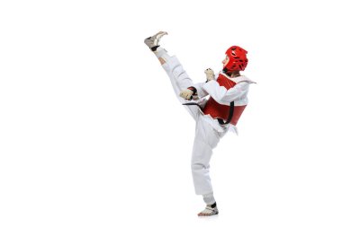 Young girl, taekwondo practitioner strikes forcibly with the foot isolated over white background. Concept of sport, skills