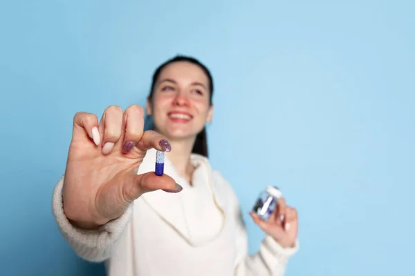 Портрет молодой белой девушки, больной, чихающей на голубом фоне. Грипп, холод, аллергия — стоковое фото