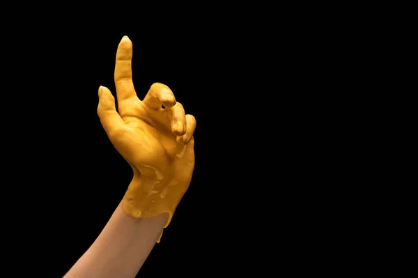 Mano umana dipinta di giallo gesticolare isolato su sfondo scuro studio. Concetto di relazione umana, simbolismo, cultura e storia — Foto Stock