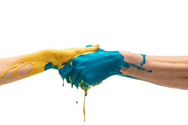 Две раскрашенные человеческие руки рукопожатия изолированы на белом фоне студии. Понятие человеческих отношений, символизма, культуры и истории — стоковое фото