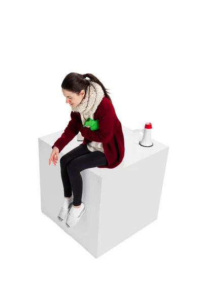 Студийный снимок молодой девушки, чувствующей себя больной, сидящей на коробке, изолированной на белом фоне. Грипп, холод, аллергия — стоковое фото