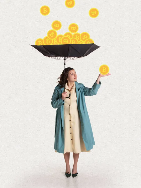 Giovane donna in stile retrò abbigliamento con ombrello in piedi sotto la pioggia bitcoin. Surrealismo. Concetto di guadagnare, risparmiare e investire denaro — Foto Stock