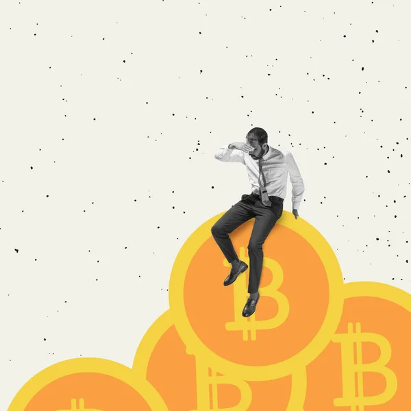 Steigende Einkommen. Junger Mann, Angestellter, Börsenmakler sitzt auf riesigen Münzen mit Bitcoin-Zeichen auf weißem Hintergrund. — Stockfoto