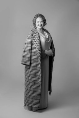 Gri stüdyo arka planında izole edilmiş güzel bir kadının tam boy monokrom portresi. Güzellik, moda, tarz, vücut pozitifliği