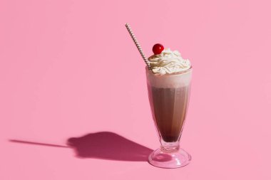 Pop sanat tasarımı. Açık pembe arka planda izole edilmiş İrlanda kahveli kokteyl bardağı. Zevk anlayışı, meşrubat, retro tarzı.