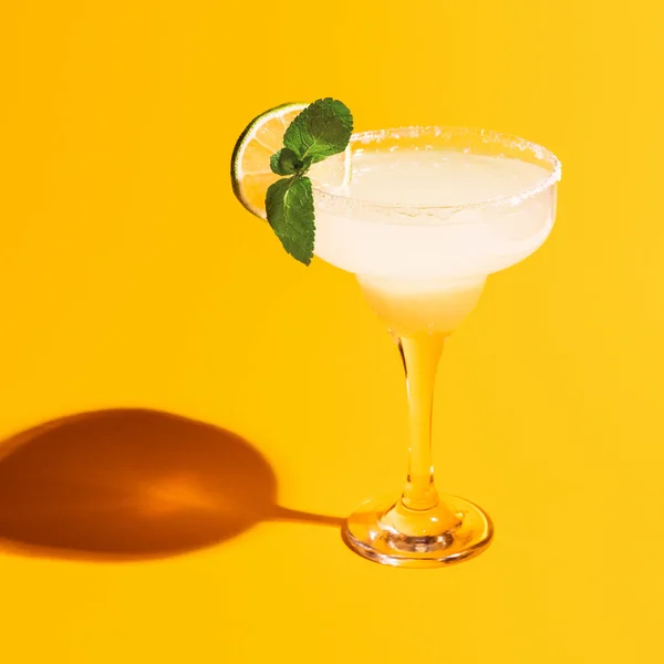 Vidro Margarita isolado em fundo de néon amarelo brilhante com sombra. Conceito de gosto, bebidas alcoólicas — Fotografia de Stock