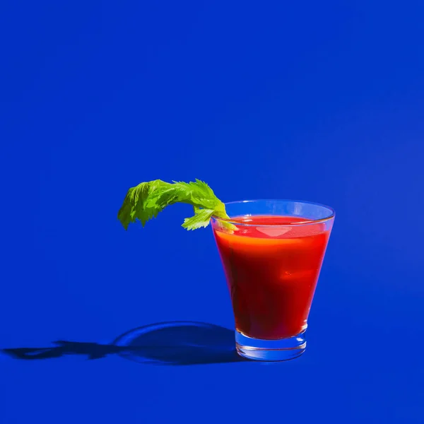 Pequeño vaso con cóctel sangriento Mary aislado sobre fondo de neón azul brillante. Concepto de sabor, bebidas alcohólicas —  Fotos de Stock