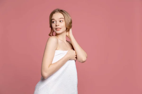 Halve lengte portret van jong mooi slank meisje in witte handdoek poseren geïsoleerd over roze studio achtergrond. Natuurlijke schoonheid concept. — Stockfoto
