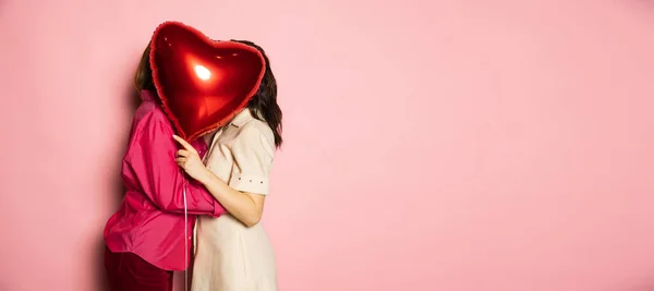 Flyer avec couple heureux tenant des ballons en forme de cœur. Fête de la Saint-Valentin. Concept d'émotions, expression faciale, amour, relations, vacances romantiques. — Photo