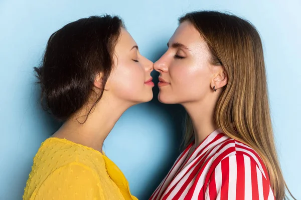 Close-up young girls, couple isolated on blue background. Valentines day celebration. Concept of emotions, love, relations, romantic holidays. — Stock Photo, Image