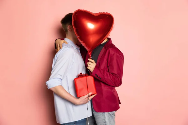 Happy couple holding balloons shaped hearts. Valentines day celebration. Concept of emotions, facial expression, love, relations, romantic holidays. — Stock Photo, Image