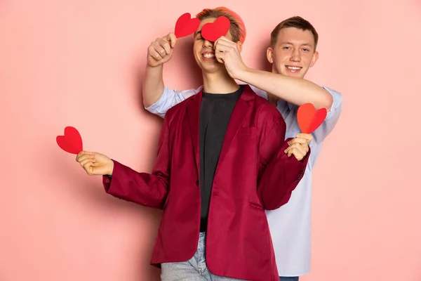 Szczęśliwi mężczyźni, młoda para trzymająca kartki z życzeniami w kształcie serc. Walentynki. Pojęcie emocji, miłości, związków, romantycznych wakacji. — Zdjęcie stockowe