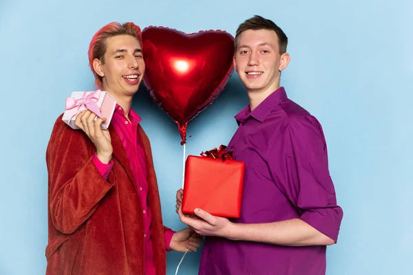Szczęśliwa para mężczyzn trzymających balony w kształcie serc. Walentynki. Pojęcie emocji, wyrazu twarzy, miłości, związków, romantycznych wakacji. — Zdjęcie stockowe