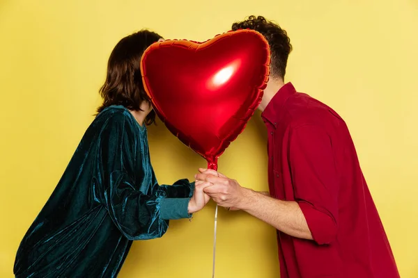 Pareja feliz, hombre y mujer sosteniendo globos en forma de corazones. Celebración de San Valentín. Concepto de emociones, amor, relaciones, vacaciones románticas. —  Fotos de Stock