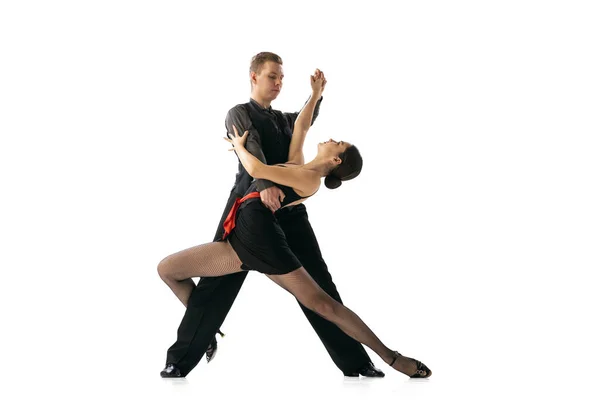 Hermoso joven deportivo bailando tango argentino aislado sobre fondo blanco del estudio. Artistas en trajes de escenario negro —  Fotos de Stock