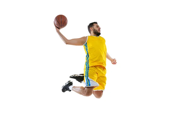 Joven deportista, jugador de baloncesto profesional saltando con pelota aislada sobre fondo blanco del estudio. Deporte, movimiento, actividad, conceptos de movimiento. — Foto de Stock