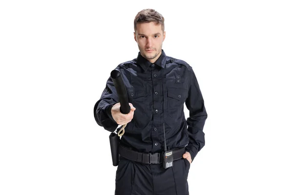 Portrait à mi-longueur d'un jeune policier portant un uniforme noir posant isolé sur fond blanc. Concept d'emploi, de soins, de loi et d'ordre. — Photo