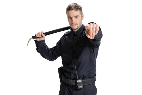 Retrato de meio comprimento de um jovem policial vestindo uniforme preto posando isolado no fundo branco. Conceito de trabalho, cuidado, lei e ordem. — Fotografia de Stock