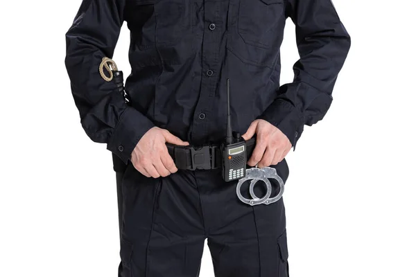 Cropped image of male policeman officer wearing black uniform with walkie-talkie and handcuffs isolated on white background. Stock Picture